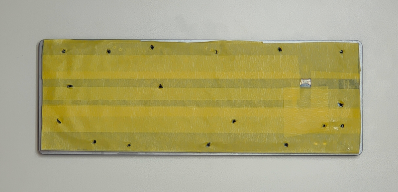 Masking tape on the keyboard, with holes for the screws