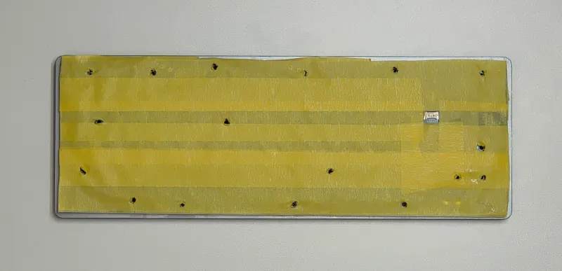 Masking tape on the keyboard, with holes for the screws